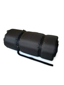 Rolled-up black self-inflating mattress secured with two adjustable straps, ready for storage or transport.